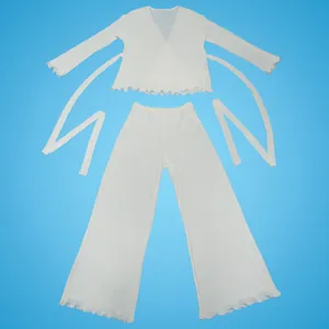 Macro view of white pleated long-sleeve top and wide-leg trousers set with ruffle hem