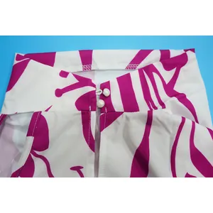 Close-up detail of pearl buttons and purple floral pattern on women's printed suit