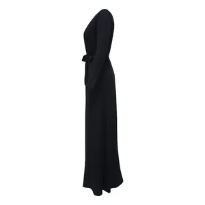 Vue latérale d'une élégante robe longue en maille côtelée noire avec ceinture assortie