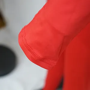 Detailed macro view of red long sleeve cuff stitching on a fitted jumpsuit bodysuit