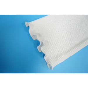 Detailed macro view of the pleated ruffled cuff on a white casual long sleeve top.