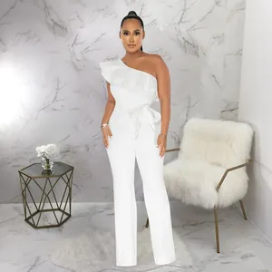 Full length view of elegant white one-shoulder ruffled jumpsuit with waist tie