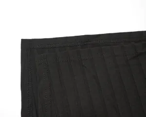 Close-up detail of black ribbed fabric showing high-elastic texture and professional stitching.