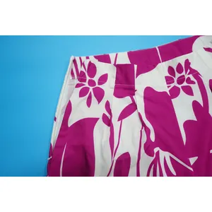 Close-up detail of stylish fuchsia floral print pants featuring a discrete side zipper.