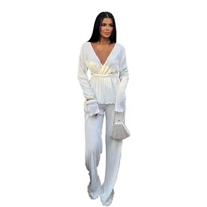 Macro view of the pleated fabric on this white long-sleeve v-neck two-piece set