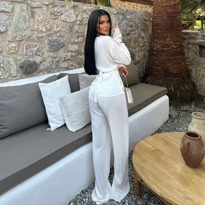 Elegant back view of white pleated long-sleeved top and wide-leg pants set on model
