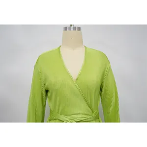 Detailed view of a light green plisse long sleeve wrap dress with elegant pleats