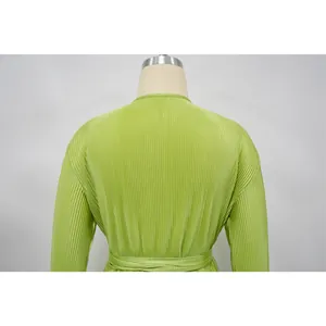 Detailed view of lime green pleated fabric texture on long-sleeved garment back