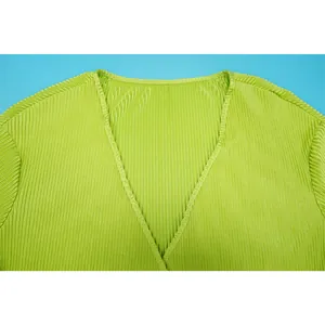 Detailed macro view of lime green pleated V-neck fabric showing fine vertical texture.