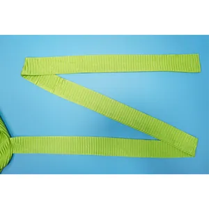 Close-up of lime green pleated fabric strap detail with fine vertical crinkle texture.
