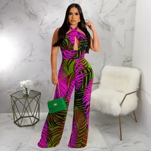 Ganzkörperansicht eines sexy Neckholder-Jumpsuits mit tropischem Blattmuster und Ausschnitt.