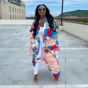 Vibrant floral print loose kimono cardigan styled with white ripped jeans outdoors