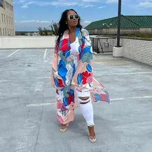 Full-length view of a woman wearing a vibrant floral print long kimono duster coat