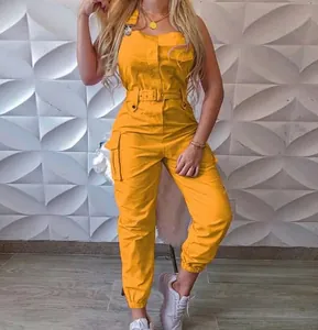 Close-up detail of stylish yellow cargo jumpsuit featuring multiple utility pockets and waist belt