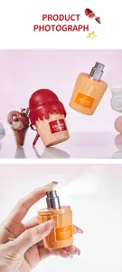 Primo piano della boccetta di profumo a forma di cupcake che spruzza nebbia su sfondo rosa.