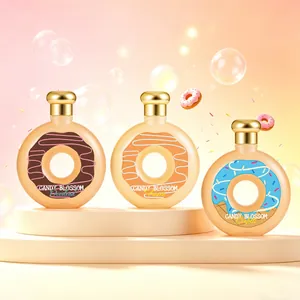 Trois flacons de parfum en forme de donut avec bouchons dorés sur un socle beige