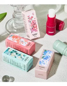 Close-up of FORMBO solid perfume stick balms in assorted floral-themed packaging