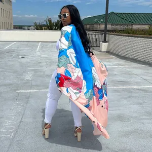 Back view of a women's long kimono cardigan with tropical leaf print in a rooftop setting