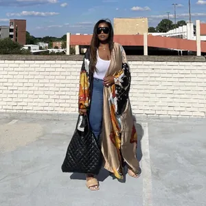 Elegant women's long kimono robe with artistic print shown in a casual outdoor setting