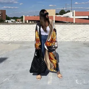 Full view of women's oversized floral print kimono cardigan in an urban street setting.