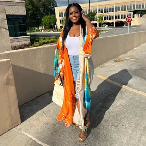 Detailed outdoor view of vibrant orange floral print long kimono duster for women
