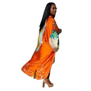 Rear profile of a model in a vibrant orange long-sleeved kimono with floral prints.