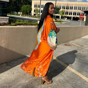 Full-length view of orange printed kimono robe with loose sleeves and floral pattern