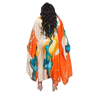 Rear view of a women's loose floral kimono cardigan with vibrant orange landscape print