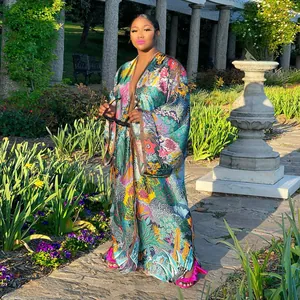 Elegant long floral print kimono robe for women styled by a model in a lush sunlit garden setting