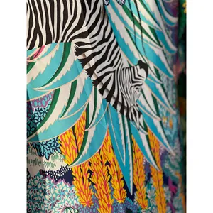Close-up of vibrant zebra and tropical palm leaf print on silk-like fabric