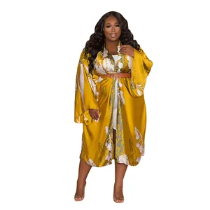 Full view of woman in yellow floral satin-style kimono robe with long sleeves