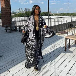 Full view of women's long-sleeved kimono coat with bold black and white abstract print