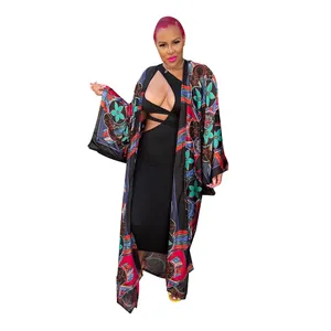 Detail of a colorful floral print kimono styled over a black cut-out midi dress