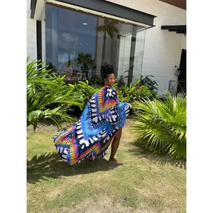 An elegant woman wearing a vibrant printed loose kimono cover-up during a bright sunny day