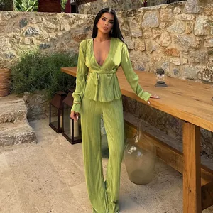 Elegant lime green pleated two-piece set with long sleeve V-neck top and trousers.