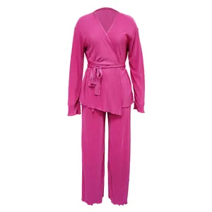 Detailed view of the vibrant fuchsia pleated long sleeve wrap top and wide-leg pants set.