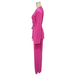 Side view detail of hot pink pleated two-piece set featuring long sleeves and waist tie