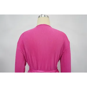 Detailed back view of a pink pleated long-sleeve blouse highlighting its unique texture