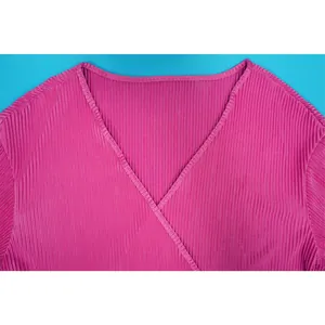 Detailed close-up view of the elegant V-neckline on a pink pleated casual top for women