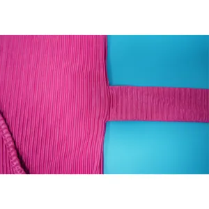 Macro view of bright pink pleated fabric showing detailed crinkle texture for casual wear