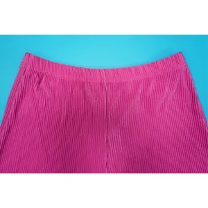 Macro detail showing the vibrant pink plissé pleated fabric and elasticated waistband
