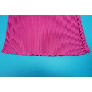 Close-up detail of pleated magenta fabric with fine vertical texture and hem stitching