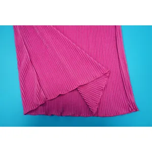 Detailed close-up view of pink pleated fabric showing fine crinkle texture and hem detail