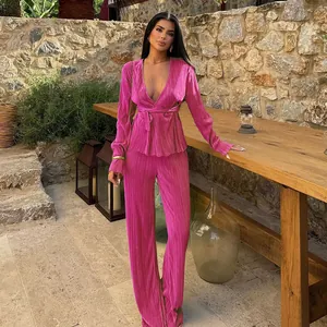 Elegant fuchsia pleated two-piece set featuring V-neck wrap top and wide-leg trousers.