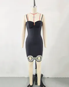 Detalle de vestido mini vendaje negro con adorno circular de pedrería en dobladillo
