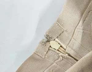 Close-up detail of the secure hook-and-eye and hidden zipper on a beige bandage skirt