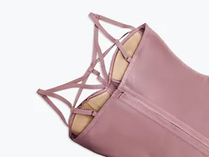 Close-up showing the intricate cross-back straps and zipper of a pink bandage dress