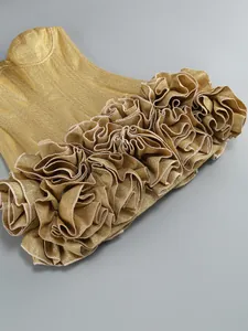 Macro close-up of premium gold shimmering fabric with elegant layered ruffle flower details.