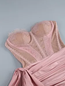 Detailed view of pink lace and sheer mesh corset bodice of a strapless dress.