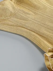 Detailed macro view of golden shimmering sequin fabric on a sexy strapless dress